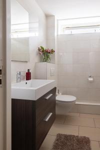 a white bathroom with a sink and a toilet at Het Woonrijk in Bennekom
