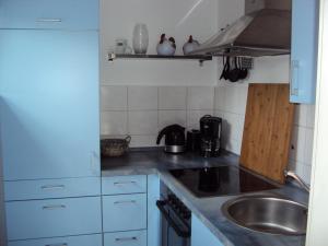 a small kitchen with a sink and a stove at Familien- & haustierfreundliche Ferienwohnung mit Garten nahe Ostsee in Schashagen +2 photos