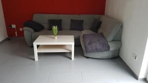 a living room with a couch and a table at Familien- & haustierfreundliche Ferienwohnung mit Garten nahe Ostsee in Schashagen