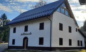 a white barn with a blue roof at NEW Locanda da Raimondo - das Knarren der Zeit in Tarvisio