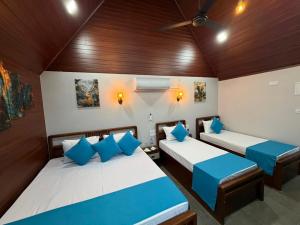 two beds in a room with blue pillows at Batti Lagoon Hotel in Batticaloa +98 photos