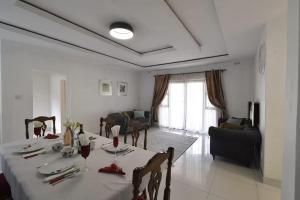 a dining room with a table and a living room at Borrowdale Top End - Apartments in Harare