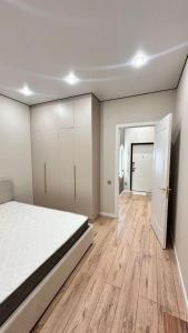 een slaapkamer met een wit bed en een houten vloer bij Angel apart in Astana