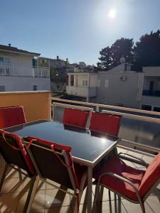 einen Tisch und 4 Stühle auf einem Balkon in der Unterkunft Apartment House Aria in Baška Voda