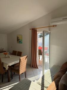 ein Esszimmer mit einem Tisch und einem Balkon in der Unterkunft Apartment House Aria in Baška Voda