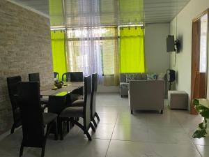 ein Esszimmer mit einem Tisch und Stühlen sowie gelben Vorhängen in der Unterkunft Casa Doña Blanca in Guaduas