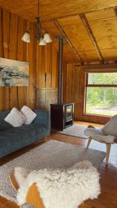 een woonkamer met een bank en een fornuis bij Cabañas Kuela in Puerto Varas
