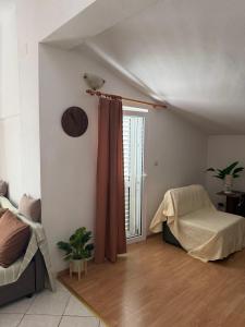 ein Wohnzimmer mit einem Bett und einem Fenster in der Unterkunft Apartment House Aria in Baška Voda