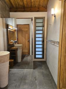 een badkamer met 2 wastafels en een houten deur bij Bois de Songe in Sainte-Rose