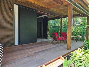 een terras met twee stoelen en een tafel erop bij Bois de Songe in Sainte-Rose