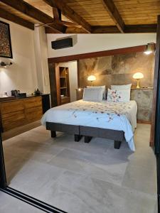 een slaapkamer met een groot bed en een badkamer bij Bois de Songe in Sainte-Rose