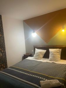 een slaapkamer met een bed met een houten hoofdeinde bij Champs Bernard in Villefranche-de-Rouergue