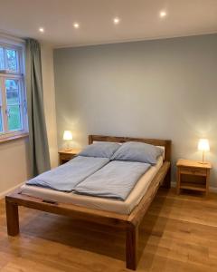 - un lit dans une chambre avec 2 lampes sur 2 tables dans l'établissement Altstadt Apartment, à Pattensen