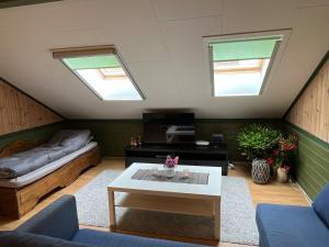 a attic living room with a bed and a table at Leilighet i låve in Gran