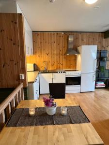 een keuken met een tafel en een witte koelkast bij Apartment in barn in Gran