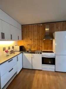 een keuken met witte kasten en een witte koelkast bij Apartment in barn in Gran
