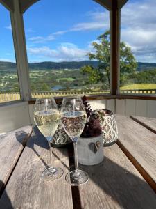 twee glazen wijn zittend op een houten tafel bij Apartment in barn in Gran +23 foto's
