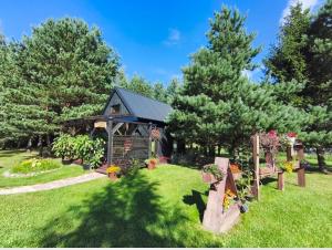 a garden with a gazebo with flowers and plants at Skujiņa in Princmuiza