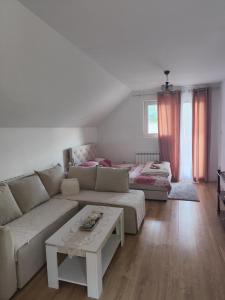 een woonkamer met een bank en een tafel bij Holiday home BOŽUR in Kolašin