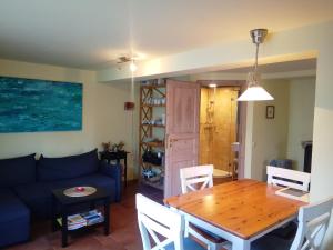 een woonkamer met een tafel en een blauwe bank bij Haus Bei Der Kirche in Oland +27 foto's
