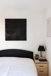 a bedroom with a bed and a table with a lamp at Comfortable Two Bedroom Home in Cwm-brân