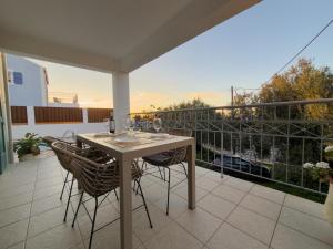 a table and chairs on a patio with a balcony at Regina Villa in Fiskardo