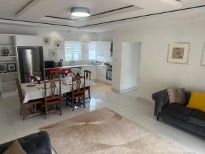 a living room with a dining table and a kitchen at Borrowdale Top End - Apartments in Harare +8 photos