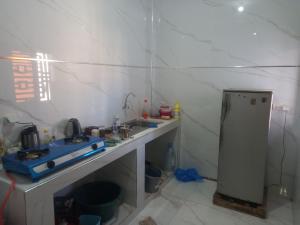 een kleine keuken met een spoelbak en een koelkast bij Femi in Keur Massar +17 foto's