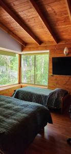 una camera da letto con due letti e una TV a schermo piatto di CASA CON PLAYA PUCURA a Licán Ray