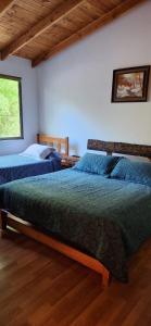 una camera da letto con due letti e una finestra di CASA CON PLAYA PUCURA a Licán Ray