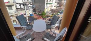 een witte tafel en stoelen op een balkon bij Luxurious Apartment Drama in Drama