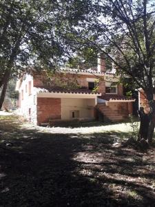 a brick building with a garage and stairs in a yard at Casa de la Bove in La Cumbre +4 photos