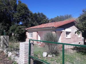 a small brick house with a green fence at Casa de la Bove in La Cumbre