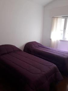 a bedroom with two beds and a window at Casa de la Bove in La Cumbre
