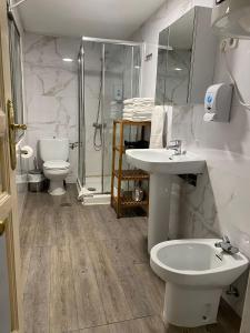 a bathroom with a sink and a toilet and a shower at Alojamiento Temporal Corazón Madrid in Madrid