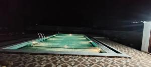 een zwembad in de nacht in een donkere kamer bij La Nature Retreat in Kuilapayam +6 foto's
