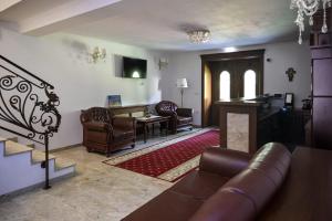 a living room with a couch and chairs and a piano at Restaurant Casa Barsan in Bîrsana