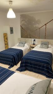 two beds with blue and white sheets in a room at Alojamiento Temporal Corazón Madrid in Madrid +7 photos