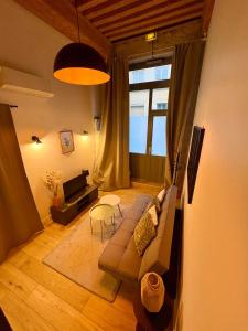 een woonkamer met een bank en een tafel bij NEW - Croix Roussienne at night in Lyon