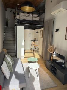 een woonkamer met een bank, een tafel en een trap bij NEW - Croix Roussienne at night in Lyon