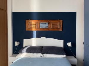 een blauwe slaapkamer met een bed met een wit hoofdeinde bij Casa Jole in Ceriale
