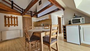 a kitchen with a table and chairs and a refrigerator at Apartmány Krásné zátiší in Krásno +32 photos
