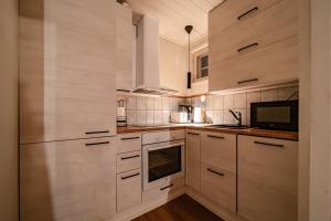 een keuken met witte kasten en een tv bij Lomavuokra Kätkäläinen, Levi Central in Levi