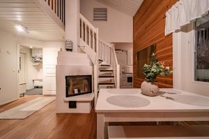 een woonkamer met een open haard en een trap bij Lomavuokra Kätkäläinen, Levi Central in Levi