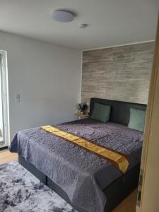een slaapkamer met een bed met een paars dekbed bij Ferienhaus Neunkirchen-Daun in Daun +3 foto's