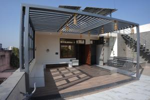 a house with awning on a patio with stairs at Apna Ghar in Jaipur