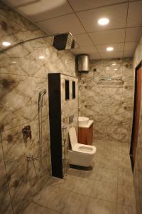 a bathroom with a shower and a toilet and a sink at Apna Ghar in Jaipur