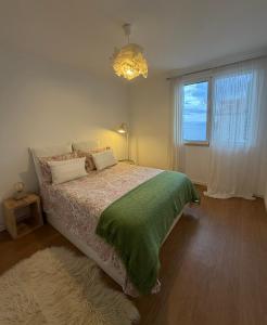 una camera da letto con un letto con una coperta verde e una finestra di Lido Sea Apart a Funchal