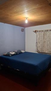 Schlafzimmer mit blauem Bett und Holzdecke in der Unterkunft Casa Mary in Panajachel