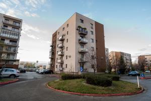 ein hohes Gebäude mit Autos auf einem Parkplatz in der Unterkunft VNS LUXURY STAY apartment in Târgovişte